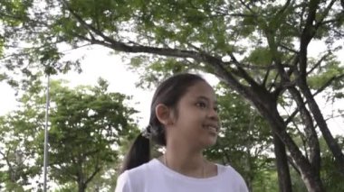 Kamu parkında sakin bir şekilde yürüyen tatlı kız, Ağır çekim..