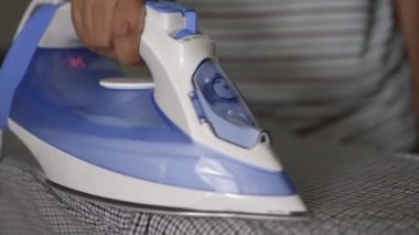 Kadın eli yakın yukarı evde tahta üzerinde giysi Ütü, ev işi konsepti.