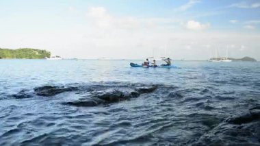 Deniz içinde Kano oynarken tanınmayan halklar ile Ao Yon Bay sahne, Phuket, Tayland bulutlu mavi gökyüzü altında Yatlar ile Andaman Denizi güzelliği.