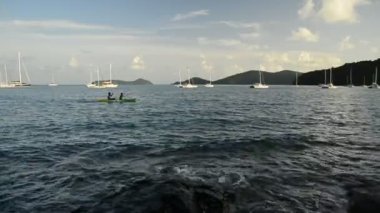 Deniz içinde Kano oynarken tanınmayan halklar ile Ao Yon Bay sahne, Phuket, Tayland bulutlu mavi gökyüzü altında Yatlar ile Andaman Denizi güzelliği.