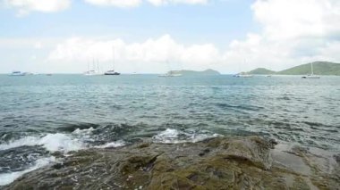 Ao Yon Beach Sahil şeridinde sahne, dalgalar düşük açı görünümünde kayalar üzerinde yıkanmış, Phuket bulutlu mavi gökyüzü altında Yatlar ile Andaman Denizi, Tayland.