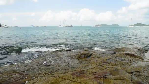 アオヨンビーチの海岸線の風景 波は低角の眺めで岩に洗い流され プーケット タイの曇り青い空の下でヨットとアンダマン海 — ストック動画