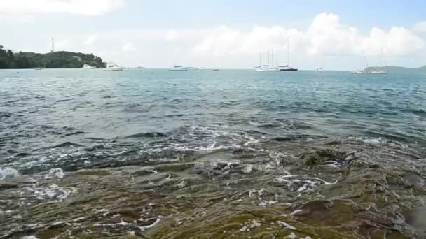 アオヨンビーチの海岸線の風景 波は低角の眺めで岩に洗い流され プーケット タイの曇り青い空の下でヨットとアンダマン海 — ストック動画