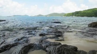 Ao Yon Beach Sahil şeridinde sahne, dalgalar düşük açı görünümünde kayalar üzerinde yıkanmış, Phuket bulutlu mavi gökyüzü altında Yatlar ile Andaman Denizi, Tayland.