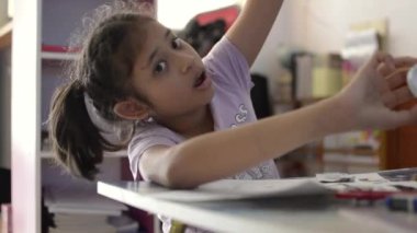 Küçük asyalı kız evde çalışma masasında ev ödevi yapıyor, Eğitim kavramı.