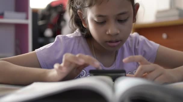 小可爱的亚洲女孩使用和观看视频从手机在书桌在家里 — 图库视频影像