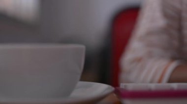 Ofis, İş ve eğitim konseptinde çalışma saatlerinde bir fincan kahve içip bilgisayar klavyesinde yazan kadın.