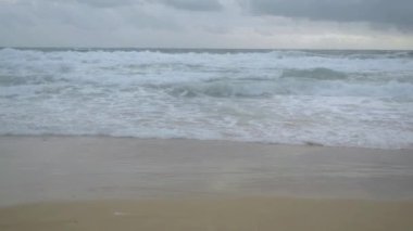 Karon plajı, Phuket, Tayland gökyüzünde bir deniz kıyısı ve yağmur bulutları üzerinde kırma dalgaları tarafından oluşturulan köpük ile tropikal kumlu plaj Manzarası.