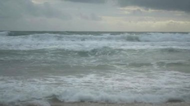 Karon plajı, Phuket, Tayland gökyüzünde bir deniz kıyısı ve yağmur bulutları üzerinde kırma dalgaları tarafından oluşturulan köpük ile tropikal kumlu plaj Manzarası.