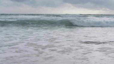 Karon plajında yağmur bulutları gökyüzü altında plaj sıçrayan büyük sörf dalgası ile deniz suyu yavaş hareket, Phuket, Tayland.
