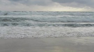 Karon plajında yağmur bulutları gökyüzü altında plaj sıçrayan büyük sörf dalgası ile deniz suyu yavaş hareket, Phuket, Tayland.