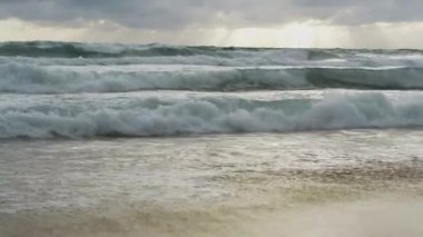 Karon plajında yağmur bulutları gökyüzü altında plaj sıçrayan büyük sörf dalgası ile deniz suyu yavaş hareket, Phuket, Tayland.