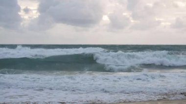 Karon plajında yağmur bulutları gökyüzü altında plaj sıçrayan büyük sörf dalgası ile deniz suyu yavaş hareket, Phuket, Tayland.