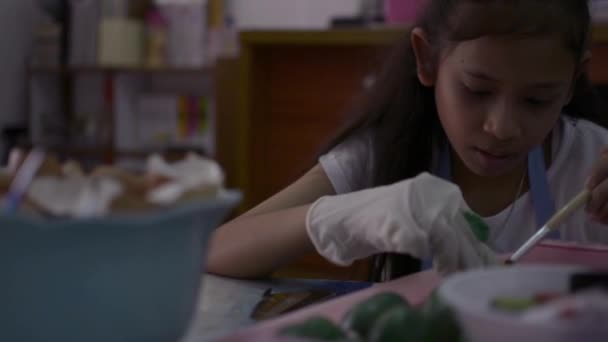 亚洲可爱的女孩正在制作工艺品从蛋壳在桌子上 年轻女孩是着色蛋壳在家里为她的家庭作业 教育概念 — 图库视频影像
