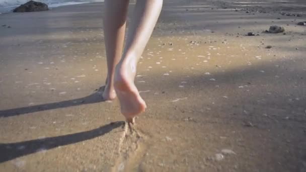 夏の間に海岸で波が壊れてビーチでゆっくりと歩くアジアの女の子の足 — ストック動画