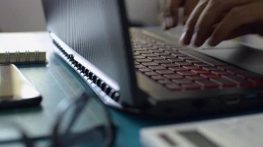 COVID-19 salgını sırasında evdeki çalışma masasında dizüstü bilgisayarda klavye yazan işadamlarının elleri. Evden çalışmak. 