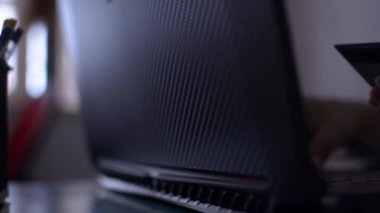 COVID-19 salgını sırasında elinde kredi kartı olan ve evdeki masada online ödeme için klavye yazan bir kadının elleri. Evden çalış..