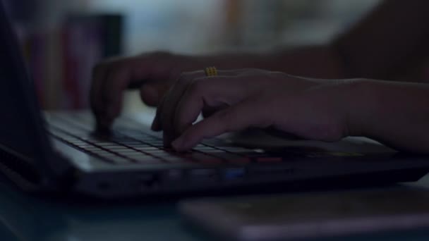 夜間作業机の上にノートパソコンのキーボードを入力するビジネス女性の手 — ストック動画