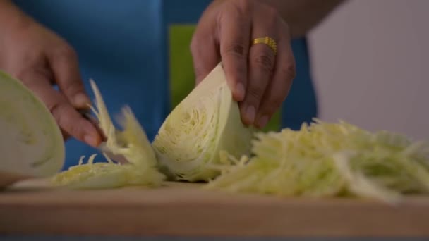 近距离拍摄女性手在木制切菜板上切卷心菜的镜头 厨房桌上放上健康食品 — 图库视频影像