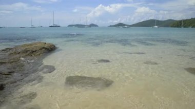 Güzel kayalık ve kumlu sahil, bulutlu mavi gökyüzünün altında berrak su, Phuket, Tayland 'da yatları olan Ao Yon Körfezi.