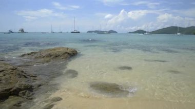 Güzel kayalık ve kumlu sahil, bulutlu mavi gökyüzünün altında berrak su, Phuket, Tayland 'da yatları olan Ao Yon Körfezi.