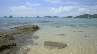 Güzel kayalık ve kumlu sahil, bulutlu mavi gökyüzünün altında berrak su, Phuket, Tayland 'da yatları olan Ao Yon Körfezi.