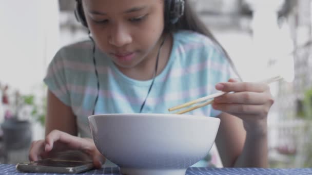 Roztomilé Mladé Asijské Dívka Ležérní Šaty Sluchátky Jíst Smažené Nudle — Stock video