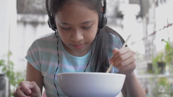 Adorable Chica Asiática Joven Vestido Casual Con Auriculares Comiendo Fideos — Vídeos de Stock