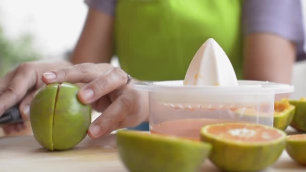 自宅で朝食を用意しながら主婦の手を閉じて絞り汁でオレンジジュースを切って絞る 自家製だ 健康的なライフスタイル スローモーション — ストック動画