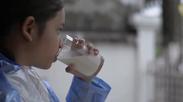 Hübsche Grundschülerin Blauem Regenmantel Trinkt Haus Ein Glas Frische Milch — Stockvideo