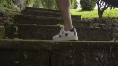 Asyalı bir kadın, eski beton merdivenlerde koşuyor ve sabah tepeye nişan alıyor. Doğal olarak çarpıcı bir park. Atış kaldırılıyor.