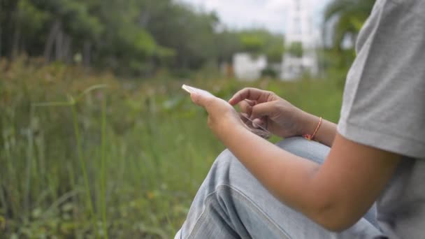 Aziatische Vrouw Casual Jurk Zit Het Gras Buurt Van Natuurlijke — Stockvideo