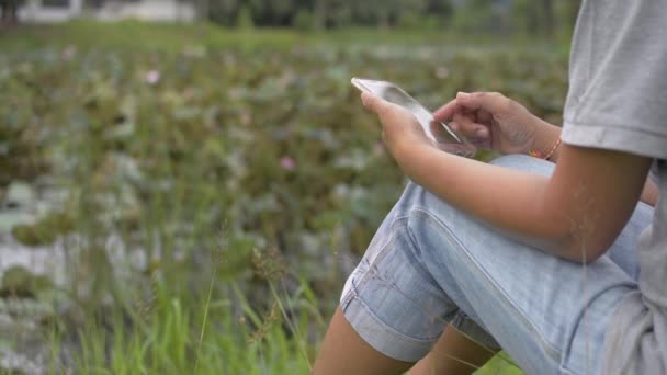 Aziatische Vrouw Casual Jurk Zit Het Gras Buurt Van Natuurlijke — Stockvideo