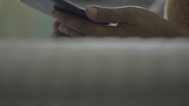 Kadının elini cep telefonuyla kapat ve yatakta yatarken sosyal medyada sörf yapmak için dokunmatik ekranda kaydır. Modern yaşam için dijital cihaz. Eğik atış.