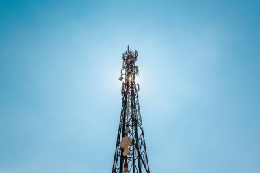 Cep telefonu antenler ve arka planda mavi gökyüzü ile uydu anteni ile Telekomünikasyon Televizyon antenler