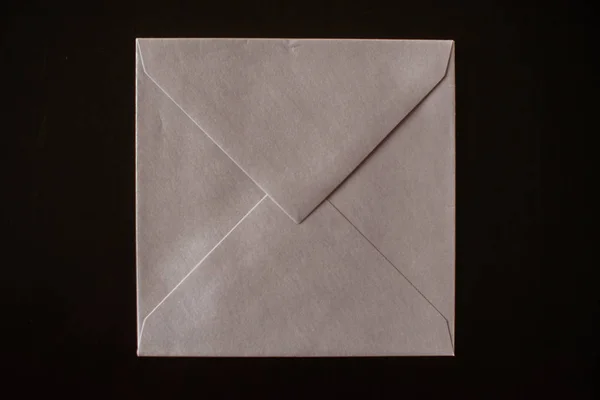 letter envelope on black background. mock-up for your design. flat lay.