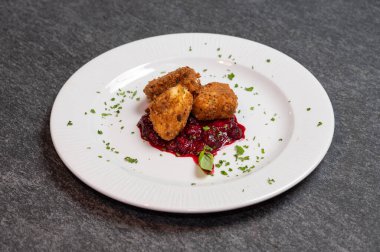 Beyaz tabakta tatlı kızılcık soslu kızarmış Camembert peyniri. Gurme Aperatif Yemekler ve Tatil Menüleri İçin Mükemmel