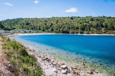 Açık mavi deniz, kayalık plajlar, çam ağaçları ve geleneksel Hırvat sahil köyü yakınlarındaki sakin körfezler manzaralı Adriyatik kıyı manzaraları