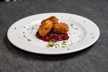 Beyaz tabakta tatlı kızılcık soslu kızarmış Camembert peyniri. Gurme Aperatif Yemekler ve Tatil Menüleri İçin Mükemmel