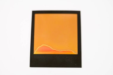 Failed instant film development abstract orange and red chemical marks on blank Polaroid photo frame on white background