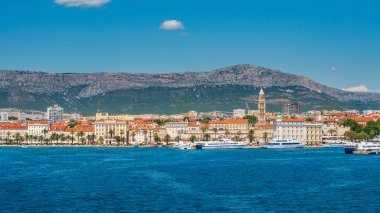 SPLIT, CROATIA  July 16, 2019 - Panoramic view of Split Riva with Diocletian's Palace, palm trees, and Jadrolinija ferries on a sunny summer day