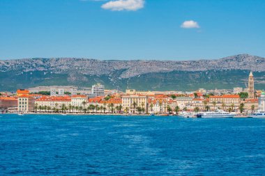 SPLIT, CROATIA  July 16, 2019 - Panoramic view of Split Riva with Diocletian's Palace, palm trees, and Jadrolinija ferries on a sunny summer day