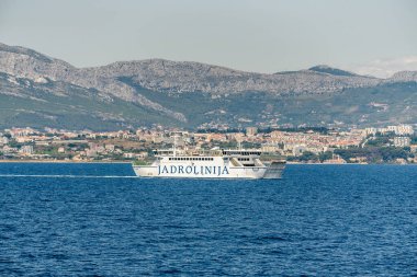 Split, Croatia  July 16, 2019 - Jadrolinija ferry Marjan sails the Adriatic Sea with the Dalmatian coastline and Mosor mountains in the background