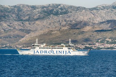 Split, Croatia  July 16, 2019 - Jadrolinija ferry Marjan sails the Adriatic Sea with the Dalmatian coastline and Mosor mountains in the background