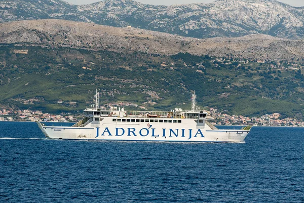 Split, Croatia  July 16, 2019 - Jadrolinija ferry Marjan sails the Adriatic Sea with the Dalmatian coastline and Mosor mountains in the background