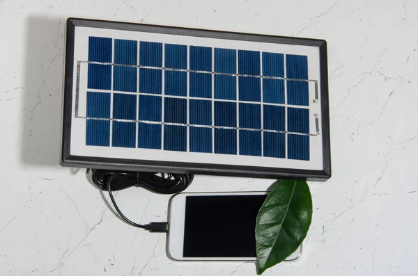 A portable solar battery for charging gadgets in traveling conditions on a test black and white background.