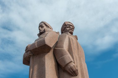 Old Riga 'nın merkezinde, bazıları Lenin' in kişisel koruması olan Letonyalı Kızıl Tüfekçilere adanmış tartışmalı bir kırmızı granit heykel bulunuyor..