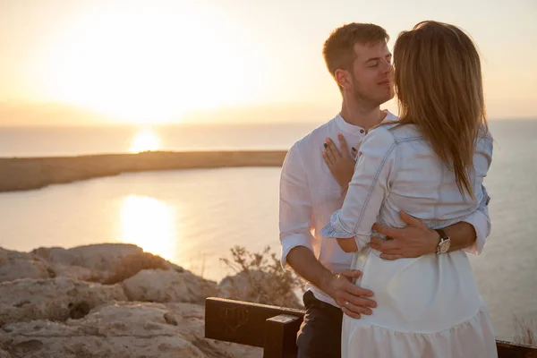 Young couple in love meeting sunrise with th e beautiful seaview on the background