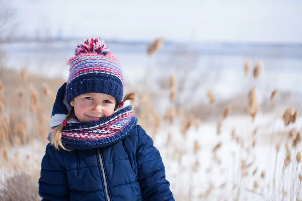 Portrait d'hiver de petite fille dans une raquette marine chaude avec rivière gelée sur fond — Photo