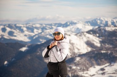 Kış spor yetişkin kadın portre Bakuriani, Gürcistan'daki arka plan üzerinde karlı dağlar
